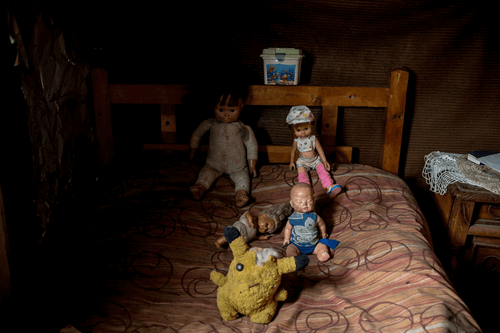 Παιδικά βρώμικα παιχνίδια στολισμένα σε κρεβάτι φτωχής οικογένειας