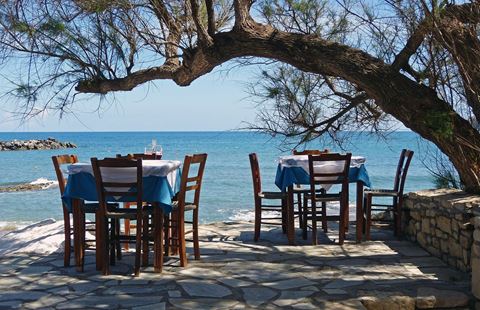 Τραπέζια και καρέκλες εστιατορίου δίπλα στη θάλασσα