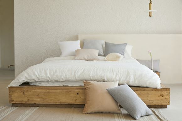 Ξύλινο κρεβάτι με στρώμα και μαξιλάρια.