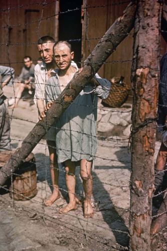 Δύο κρατούμενοι πίσω από κάγκελα σε στρατόπεδο συγκέντρωσης