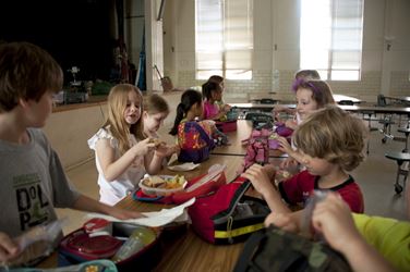 Children seating on chair eating at school | Unsplash