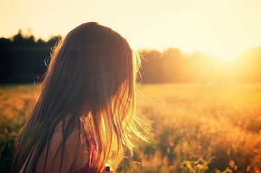 Κορίτσι στη φύση κοιτάζει τον ήλιο